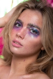 Paint splash, metallic gold and irridescent purple and pink tones on model Mia's makeup