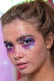 Paint splash, metallic gold and irridescent purple and pink tones on model Mia's makeup