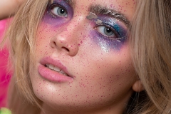 Paint splash, metallic gold and irridescent purple and pink tones on model Mia's makeup