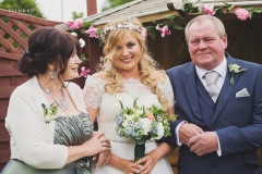 Bride Steph looks beautiful, stood between the mother of the bride and the father of the bride. Wedding reception at The Lordstones, North Yorkshire. Makeup by Gemma Rimmington.