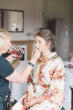 Bride Helen getting her makeup done by Gemma Rimmington on the wedding morning at Grinkle Park, North Yorkshire.