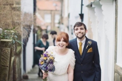 Bride and Groom walking to their wedding at Robin Hoods Bay.  Image by Sasha Lee Photography