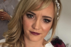 Bride steph is wearing a flawless foundation, dark berry lipstick and a defined eye makeup.